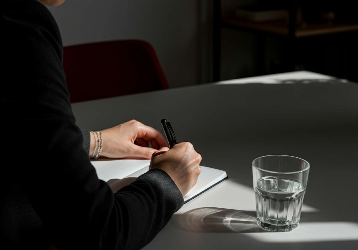 A person writing in a journal, demonstrating the practice of reflective journaling for sharpening critical thinking skills.