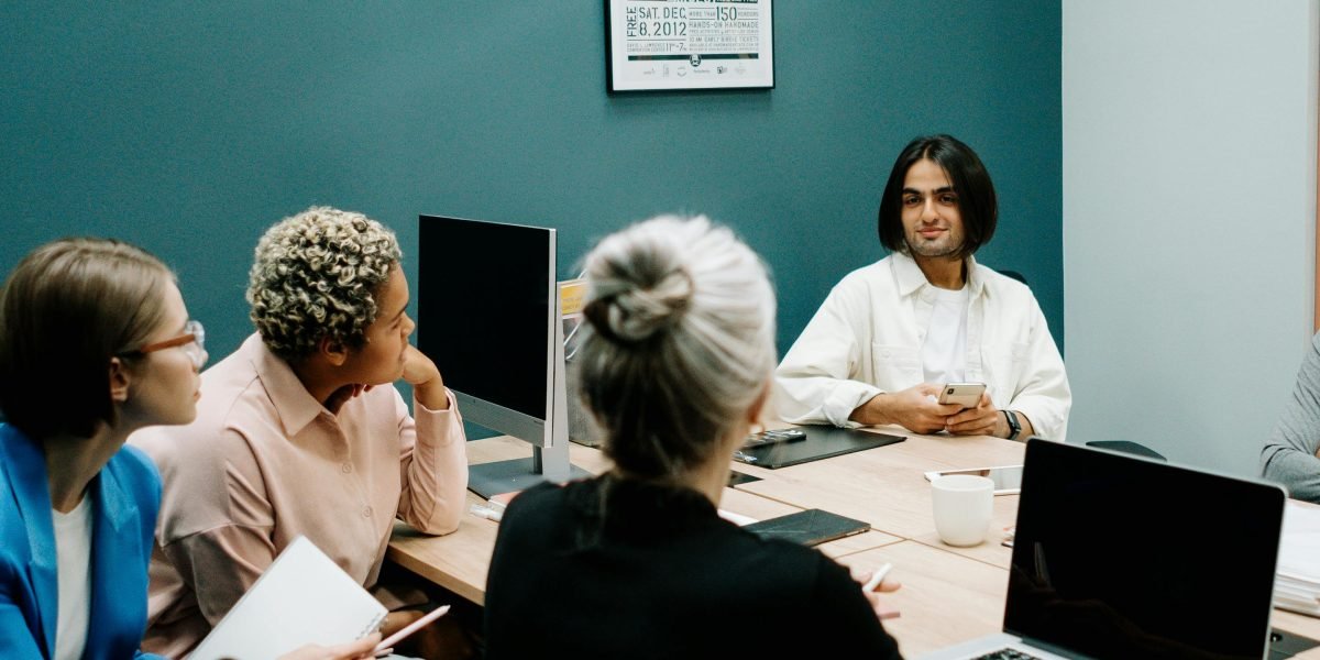 A business team in a meeting, actively discussing potential project risks and challenges, symbolizing a 'pre-mortem' exercise.