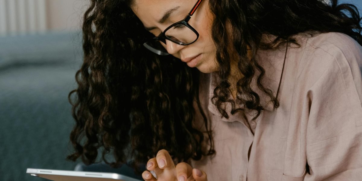 A person thoughtfully consuming and evaluating digital content, symbolizing the need for critical thinking skills in a world of information overload.
