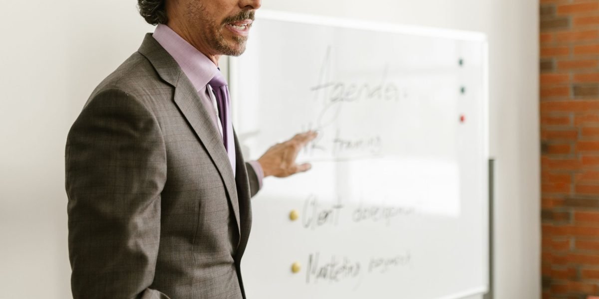 A person effectively explaining an idea using a whiteboard, demonstrating clear communication.