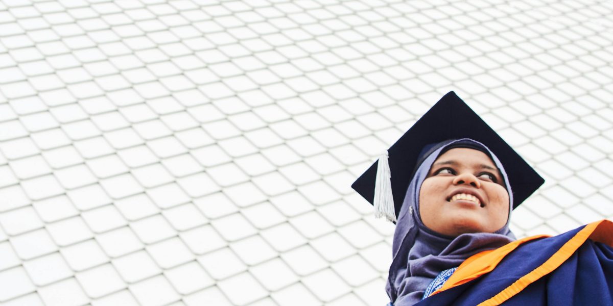 A confident young adult in graduation attire, looking towards a bright future, symbolizing long-term success.