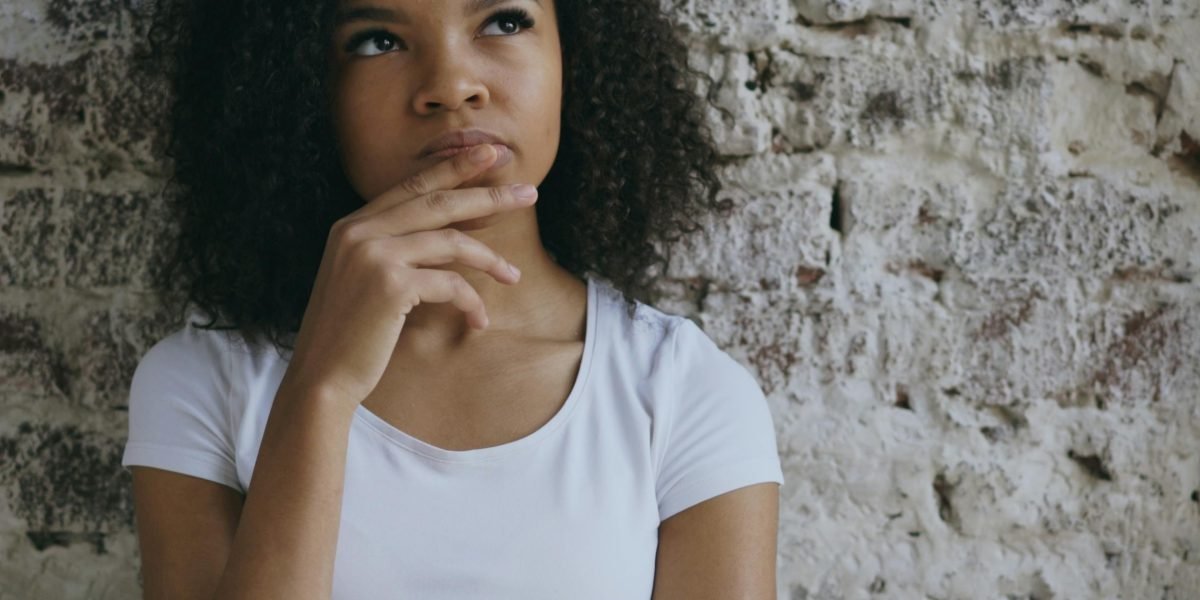 A person deep in thought, representing the critical thinking process when faced with important life choices like educational pathways.