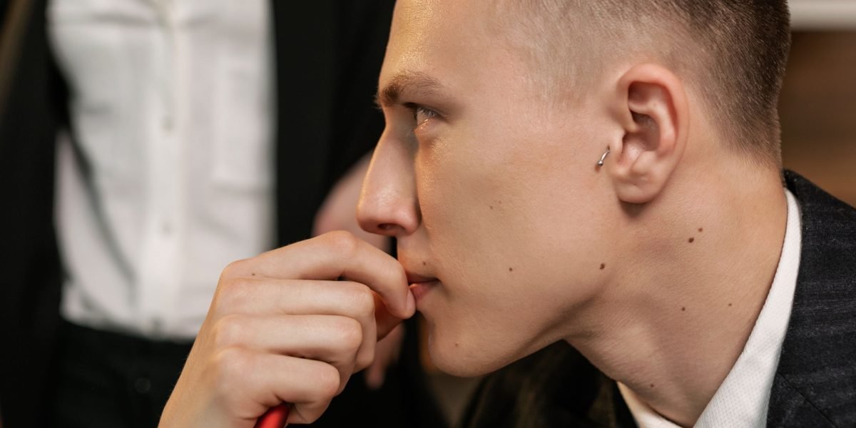 A professional pauses thoughtfully during a discussion, demonstrating careful consideration before agreeing.
