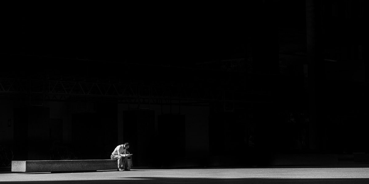 A person pausing for reflective thought in a public setting, highlighting the need to resist cognitive offloading to technology.
