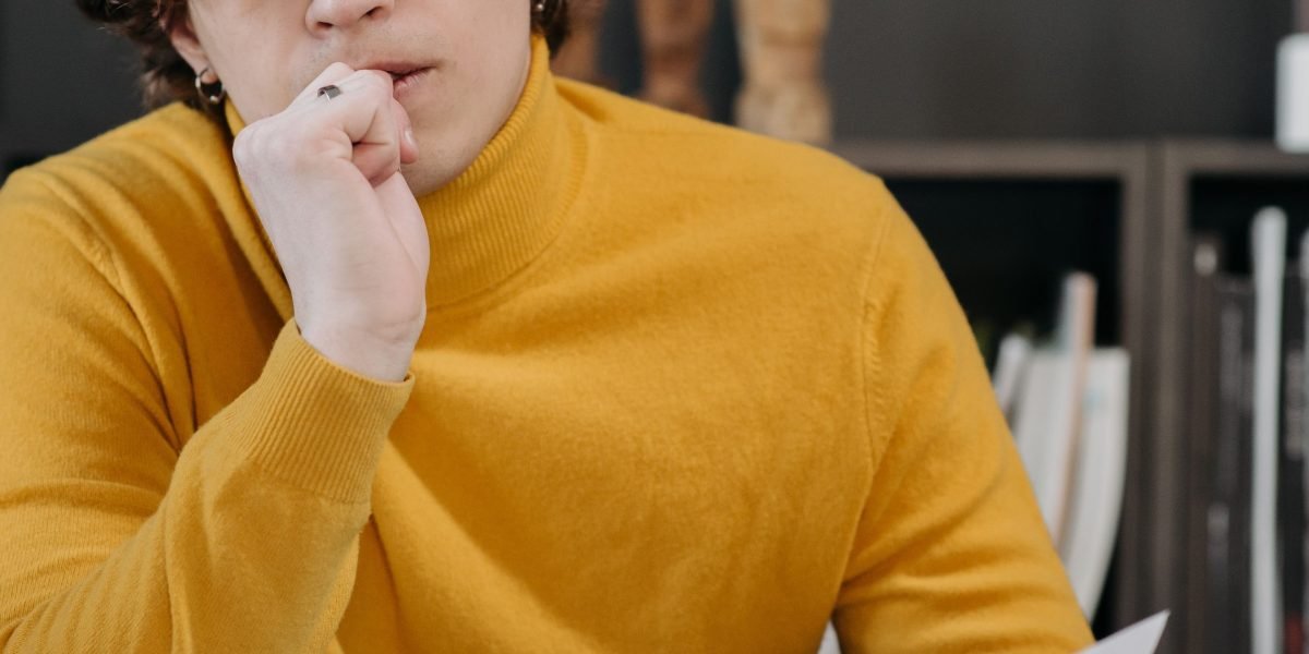 A person in a professional setting thoughtfully evaluating options, symbolizing the process of overcoming cognitive biases.
