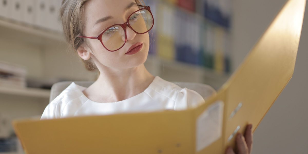 A person thoughtfully reviewing academic transcripts and planning their educational pathway.